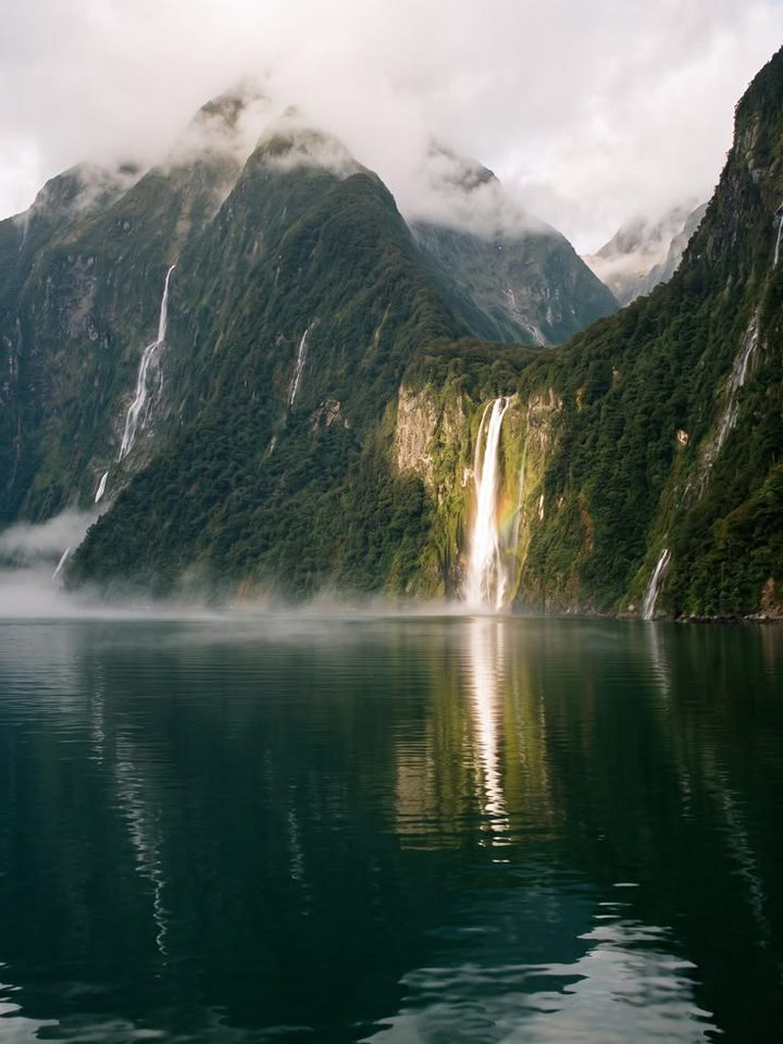 A waterfall falling into a still fjord in Canada